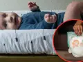 Niemowlę na przewijaku, obok pieluszka. Czas na zmianę pieluszki na większą?