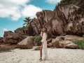 Kobieta w białej narzutce na plaży Anse Source d'Argent, Seszele. Co zobaczyć? Monumentalne granitowe skały i turkusowe niebo.