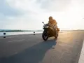 Motocyklista przemierza malownicze trasy motocyklowe pomorskie w blasku zachodzącego słońca.