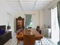 Elegancka jadalnia w stylu kolonialnym z drewnianym stołem, witryną i zdobioną skrzynią.