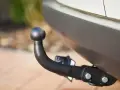 Gancio traino nero montato sul paraurti di un'auto, pronto per il traino secondo il codice della strada.