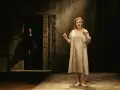 Aktorka w prostej sukni opowiada o tragicznym micie o rodzie Labdakidów. W mroku majaczy postać.