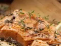 Delicioso salmón al horno, jugoso y dorado, con hierbas frescas y pimienta.