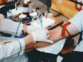 Po oddaniu krwi, zasłużona kawa. Personel medyczny pobiera krew od dawcy, przygotowując wszystko do dalszych badań.