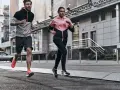 Coppia in corsa running in città, con abbigliamento sportivo colorato.