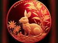 Złoty królik na tle roślinności, symbol chińskiego znaku zodiaku 1987.