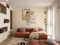 Un soggiorno moderno con divano color terracotta e tappeto geometrico. L'arredamento è pensato per abbinare tappeto e divano, creando un ambiente accogliente.