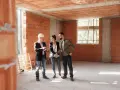 Inżynier prezentuje klientom cennik usług budowlanych na budowie.