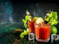 Dwa drinki Krwawa Mary z łodygami selera, limonką i piklami, ozdobione przyprawami i lodem.