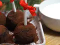Chokladbollar på pinne, pudrade med kakao, redo att doppas i varm choklad. Röda band pryder pinnarna.
