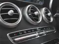 Trzy okrągłe nawiewy wentylacji w samochodzie, z pokrętłami do regulacji. Poniżej panel sterowania klimatyzacją, z przyciskami AUTO i MAX. Czekam na bardzo gorące powietrze z nawiewu.