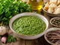 Una ciotola di salsa verde, perfetta per la tua ricetta, con ingredienti freschi come prezzemolo, aglio, capperi e acciughe.