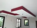 Plafond moderne avec caisson décoratif rouge et emplacements pour spots.