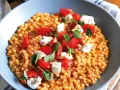 Fregola sarda ricetta originale: pasta tostata con pomodorini freschi, mozzarella e basilico, un piatto estivo profumato.