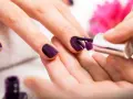 Applicazione smalto viola su unghie. Scopri come usare la fibra di vetro per unghie per un look impeccabile.