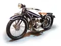 Klasyczny motocykl BMW z lat 20. XX wieku, czarny z białymi pasami, z brązowym siodłem. Ikona historii BMW.