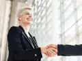 Due professionisti si stringono la mano, un gesto di accordo e fiducia. Sono colleghi raccomandati sul lavoro, pronti a collaborare.