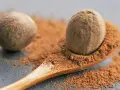 Eine Muskatnuss auf einem Holzlöffel mit gemahlenem Muskatnuss. Vorsicht bei Muskatnuss in der Schwangerschaft.