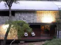 Modern house with a striking glass block installation, bathing the interior in warm light.