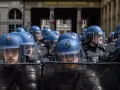 Un grupo de gendarmes con cascos azules y escudos protectores se prepara para mantener el orden frente al Conseil Constitutionnel.