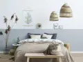 Sypialnia z łóżkiem i dwukolorową ścianą, pokazującą, jak połączyć dwa kolory na jednej ścianie. Wnętrze w stylu boho.