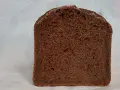 Kawałek ciemnego, puszystego chleba czekoladowego z widocznymi porami. Idealny na słodkie śniadanie.