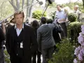 Simon Baker, con la sua nuova fidanzata, è circondato da telecamere e microfoni durante un evento all'aperto.