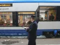 Konduktor sprawdza dane na tablecie. Zastanawiasz się, ile kosztuje bilet u konduktora? Wnętrze pociągu z siedzeniami.