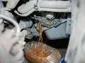 Flüssigkeit tropft aus einer undichten Wasserpumpe in einen Behälter.