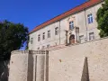 Krapkowice zamek zwiedzanie: kamienne mury i zabytkowy budynek zamku pod błękitnym niebem.