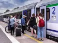 Ludzie z bagażami i rowerami czekają na pociąg PKP. Może właśnie skorzystają ze zniżki PKP na podróż?
