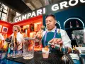 Barman nalewa Aperol do drinka, w tle logo Campari.