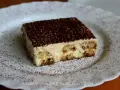 Pyszne tiramisu, czyli zabajone, na białym talerzu, posypane kakao.