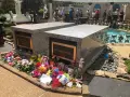 Gräber von Lisa Marie und Benjamin Keough, umgeben von Blumen. Viele Besucher ehren das Erbe von Elvis Presley.