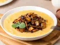 Polenta cremosa con champiñones salteados y una ramita de salvia. Un plato reconfortante que te hará preguntar: ¿polenta que es? ¡Deliciosa!