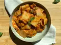 Piatto di pasta alla siciliana con rigatoni, melanzane e pomodoro, guarnito con basilico fresco.