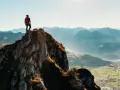 Wspinacz na szczycie skalistej góry, podziwiający panoramę gór i doliny. To jest wejście na Rysy.