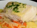 Cogote de merluza jugoso y tierno, servido sobre patatas y tomate, con un toque de perejil fresco.