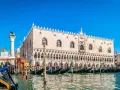 Gondole ormeggiate davanti a Palazzo Ducale, un must per chi cerca cosa vedere a Venezia. Il Leone di San Marco veglia sulla laguna.