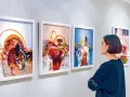 Kobieta ogląda abstrakcyjne obrazy w galerii sztuki.