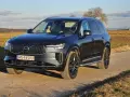 Ciemnoszary Volvo XC90 T8 na tle jesiennego krajobrazu. Elegancki SUV z nowoczesnym grillem i światłami LED.