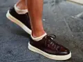 Un uomo indossa sneakers marroni con calze bianche a vista. Un look casual ma curato, perfetto per chi cerca quali calze con sneakers uomo.