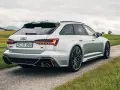 Srebrne Audi RS6 Avant z pakietem ABT na tle zielonych wzgórz. Sprawdź audi rs6 cena i możliwości tego potwora.