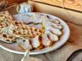 Lomo de orza en rodajas, servido con pan crujiente y ajo. Un plato rústico y delicioso.