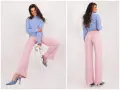 Modelka w pudrowym różu z czym łączyć stylizacje. Szerokie spodnie i błękitny sweterek tworzą elegancki zestaw.