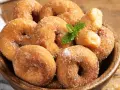 Rosquillas de la abuela esponjosas, cubiertas de azúcar y canela, con una ramita de menta. ¡Un placer casero!
