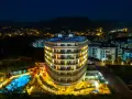 Nocny widok na lśniący hotel Michell z basenem i oświetlonymi pokojami. Wiele pozytywnych michell hotel spa opinie potwierdza jego urok.