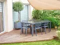 Terrasse mit Tisch und Stühlen, Sonnensegel und üppiger Bepflanzung. Tolle selber balkon sichtschutz ideen für Privatsphäre.