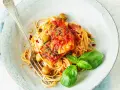 Spaghetti Puttanesca przepis: makaron z rybą w sosie pomidorowym, oliwkami, kaparami i bazylią. Pyszne danie gotowe do podania.