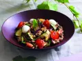 Insalata di farro estiva con verdure grigliate, pomodorini, mozzarelline e basilico fresco.
